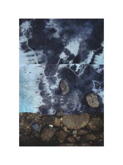 A flat-lay style shot for Adiv, where the tie-dyed fabric is placed on the rocks to mimic the patterns of the sea foam. This shows a conceptual approach to product photography.