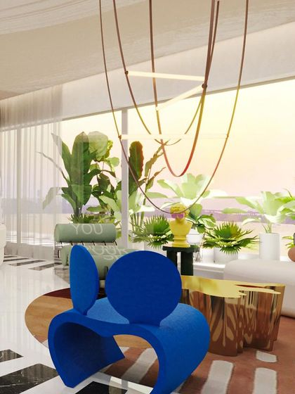 A close-up of the living area, featuring a bold blue sculptural chair and gleaming gold coffee tables. The space is a playful dialogue between form, color, and function.