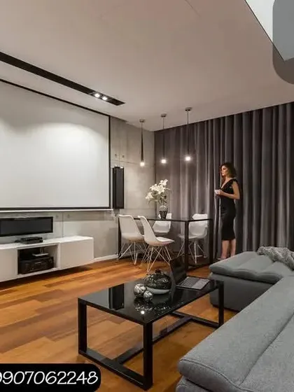 Another example of integrating a high performance home theater into a living room. The setup includes a large projector screen, tower speakers, and a dedicated subwoofer, all arranged to deliver immersive sound and visuals within a stylish, everyday living space.
