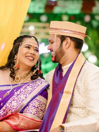 A lovely portrait of the couple seated together, their coordinated purple and white outfits looking vibrant against the yellow decor.