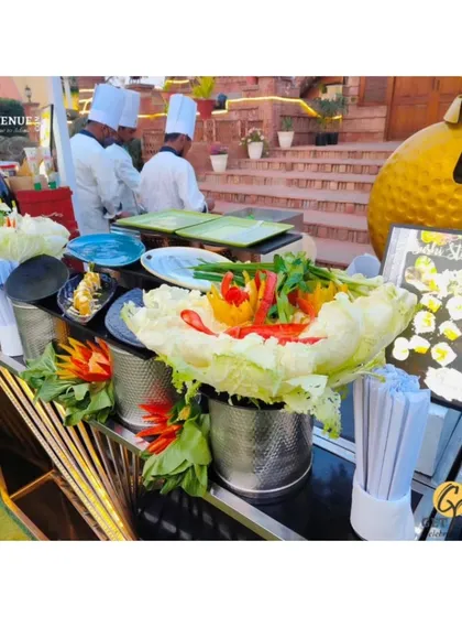 The setup of our live sushi and dim sum station, decorated with carved vegetables, ready for service at an outdoor event.