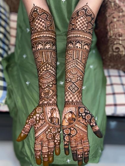 This custom bridal design features couple portraits surrounded by floral patterns. The arms are adorned with traditional elephant motifs and swastikas.