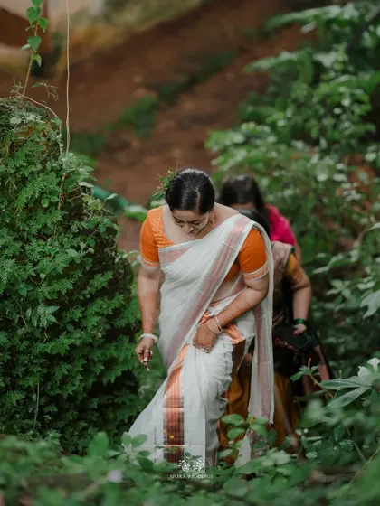 The bride walking through a dense green path, a moment of serene beauty in nature.