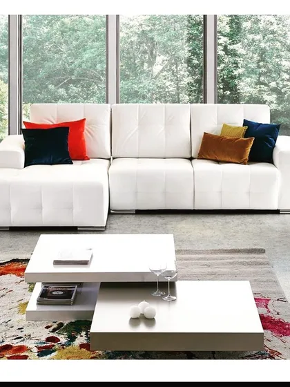 This all-white L-shaped sofa demonstrates a clean, timeless aesthetic. Paired with a modern nesting coffee table, it creates a bright and airy living space that you can personalize with colorful accents.