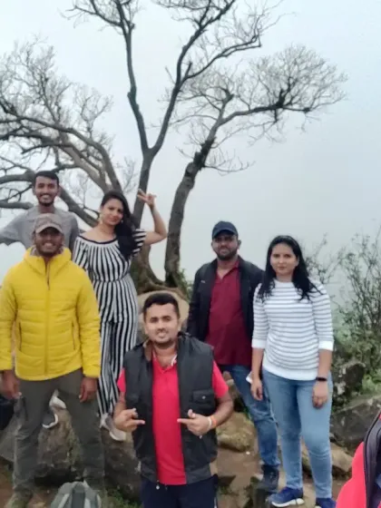 A group selfie on a misty hilltop, capturing the joy of reaching the summit together.