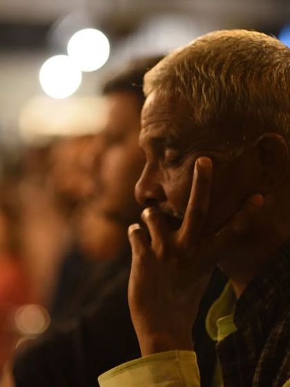 A listener lost in thought during a performance. Music has a way of transporting us, and creating that space for reflection is a key part of our baithak events.
