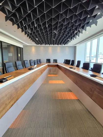 Conference rooms are where big ideas happen, so they shouldn't be boring. I designed this U-shaped boardroom with a dramatic, black acoustic ceiling that absorbs sound and adds incredible visual texture. The custom table and integrated lighting make it a highly functional and impressive space.