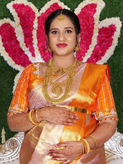 Yashaswini looking radiant and happy, cradling her baby bump at her seemantham ceremony.
