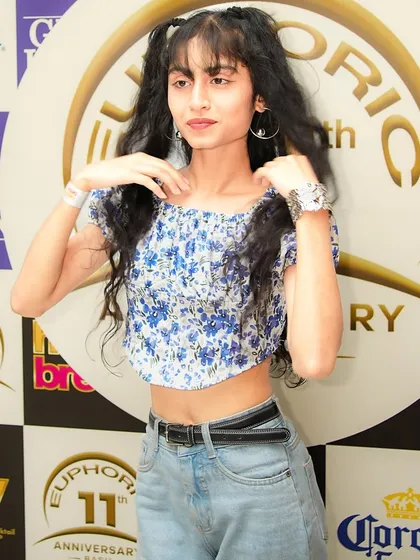A partygoer posing at the photo-op wall during the club's anniversary. My events attract a fashionable and fun-loving crowd.