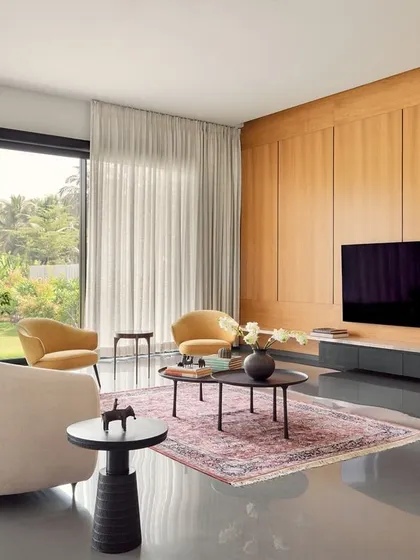 The living room of this farmhouse, with direct views of the Nilgiris, is designed for unwinding. I combined traditional Kota stone flooring with modern furniture and a warm wood-panelled wall to create a space that feels both contemporary and deeply connected to its natural surroundings.