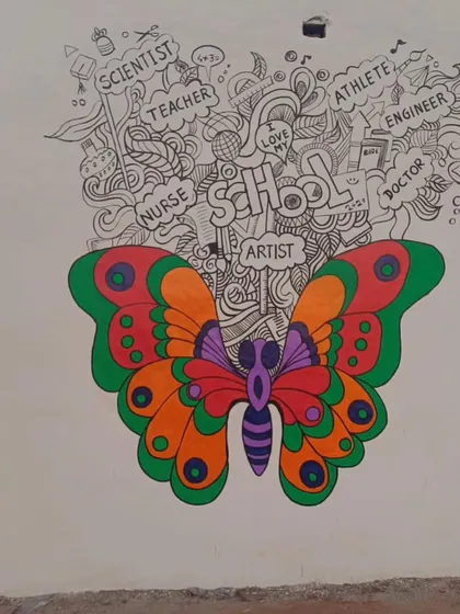 An abstract butterfly mural with wings of vibrant color, with doodles above representing future career paths like "Scientist," "Teacher," and "Artist."