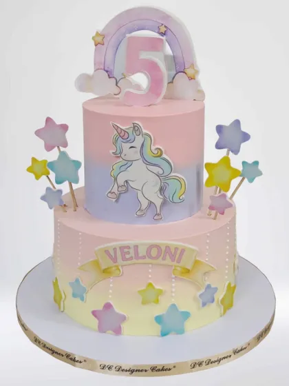 A dreamy two-tier unicorn cake with a pastel rainbow color palette. This whipped cream cake is adorned with stars and a cute unicorn topper, making it a magical choice for a 5th birthday.