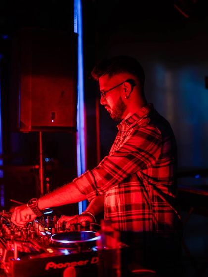 In the zone with a plaid shirt, mixing under red and blue lights. Music puts me in another zone.