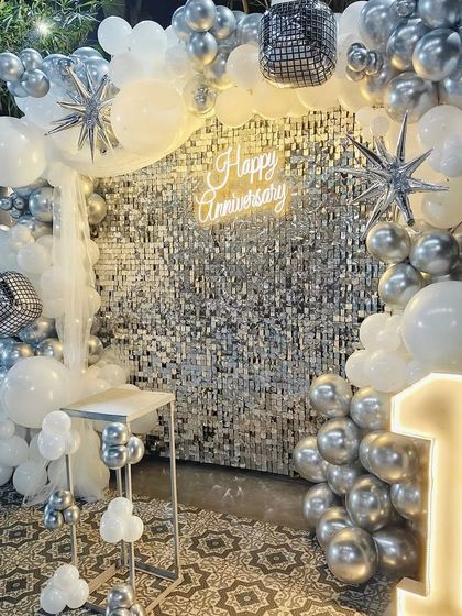 Another angle of the stunning silver and white first-anniversary decor, highlighting the disco ball and star-shaped balloon accents.