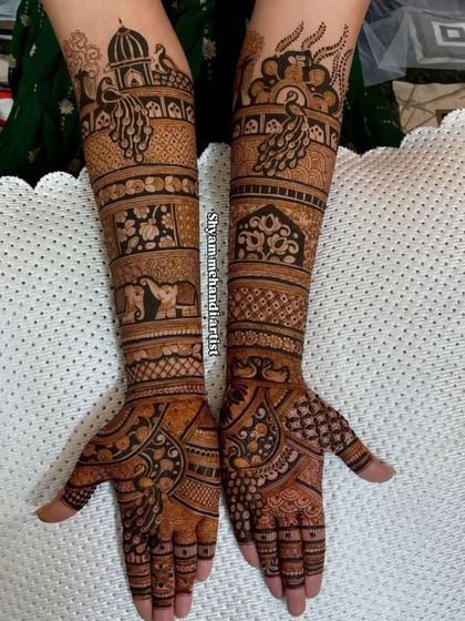 A traditional design with peacocks, elephants, and architectural domes covering the arms.