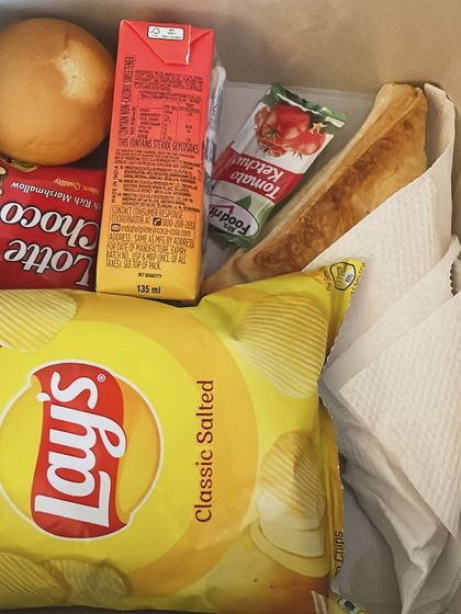 An example of a snack box we prepared for an event. This one includes a bread pakoda, a juice box, chips, and a sweet treat, making it a perfect grab-and-go option.