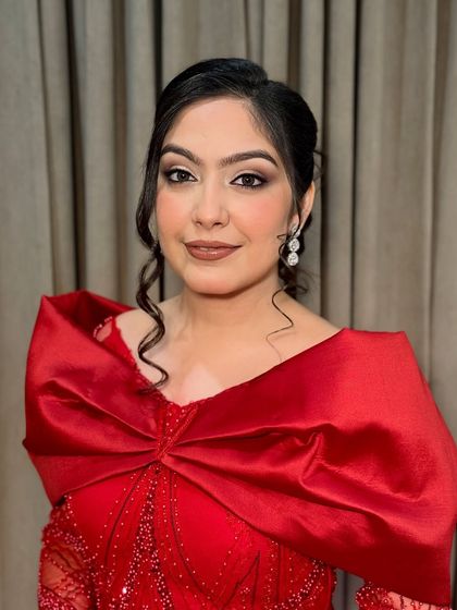 A full look of Jasleen in her stunning red gown. The makeup is balanced to complement the drama of the outfit.