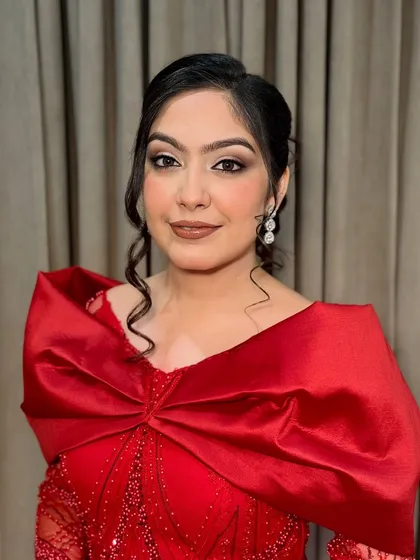 A full look of Jasleen in her stunning red gown. The makeup is balanced to complement the drama of the outfit.