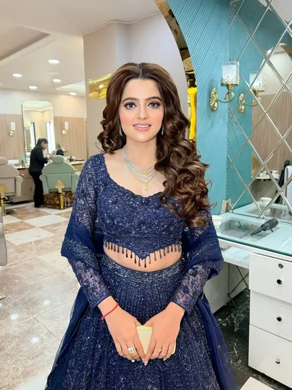 A stunning engagement bride in a royal blue lehenga. We gave her a classic glam look with soft curls and defined eyes.