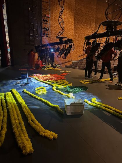 The stage being prepped with flowers before a show. The setup and stage design are integral to the performance, and a lot of work goes into preparing the space.