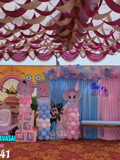 For a large outdoor or hall event, I can create an expansive backdrop like this one. It features pink and blue drapes, elephant cutouts, and a crescent moon prop for a complete themed look.
