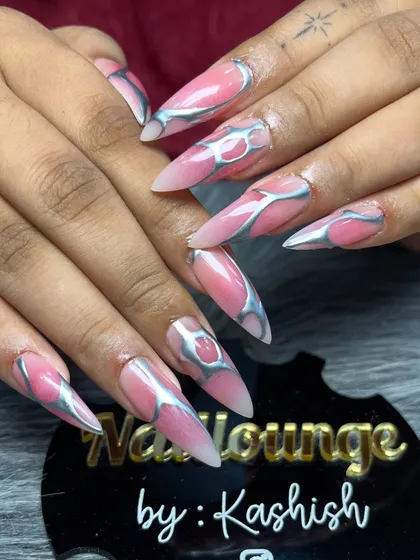 For those who love a bold and edgy look, I create designs like this. This set features long stiletto extensions with a pink base and a raised, metallic silver chrome design for a futuristic 3D effect.
