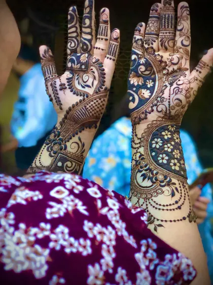 A unique design with a large crescent moon shape on the back of the hand, filled with intricate floral patterns.