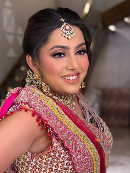 A smiling portrait of the client, looking happy and beautiful. The vibrant makeup enhances her joyful expression.