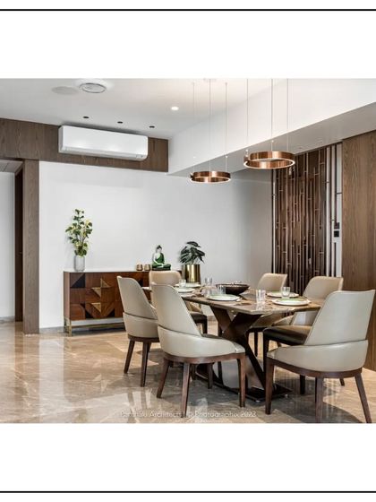 Functionality meets artistry in this dining area. A custom sideboard with a geometric pattern provides storage, while the warm wood tones and polished marble floor create a luxurious and inviting atmosphere.
