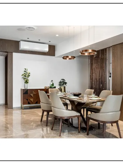 Functionality meets artistry in this dining area. A custom sideboard with a geometric pattern provides storage, while the warm wood tones and polished marble floor create a luxurious and inviting atmosphere.