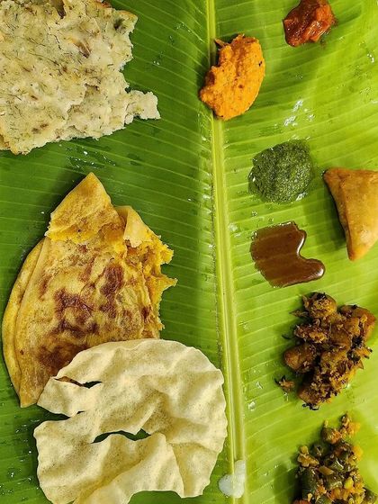 This top-down view showcases some of the stars of the Yele Oota, including a crispy papad, a sweet bele holige, and a savory samosa, offering a mix of textures and tastes.
