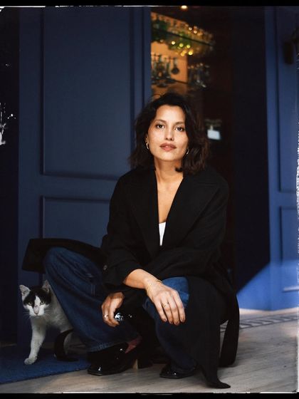 A quiet, intimate portrait. The way she crouches down to the cat's level shows a deep sense of connection and gentleness.