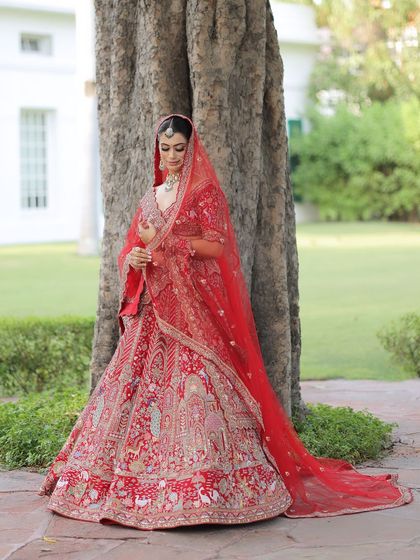A beautiful shot of the bride in her red lehenga. Her makeup is classic and timeless, designed to make her feel like royalty on her special day.