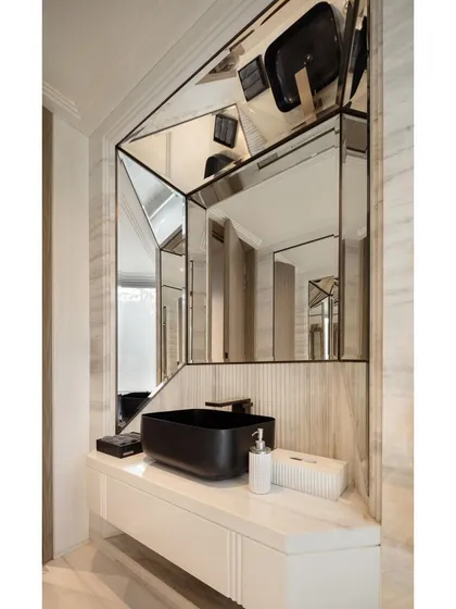 The powder room in the Delhi office is articulated with clean, crisp lines. A geometric mirror arrangement and ribbed natural stone backsplash create a modern and expressive design statement.