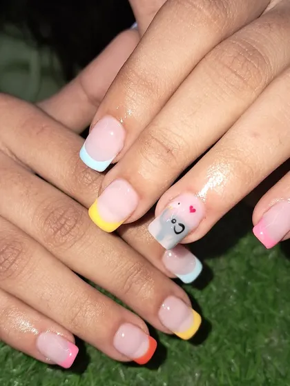 A fun, multi-colored French manicure perfect for summer, with a cute smiley face accent nail.