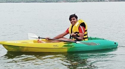A smiling participant in a two-tone kayak at our Karwar camp, perfectly capturing the fun of learning a new water sport.