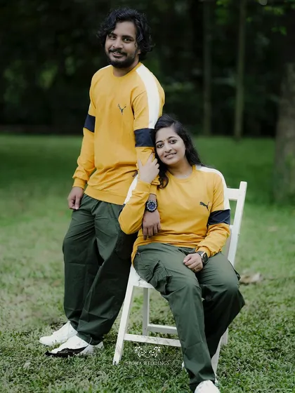 A sweet portrait of the couple, she seated and leaning against him, both looking happily at the camera.