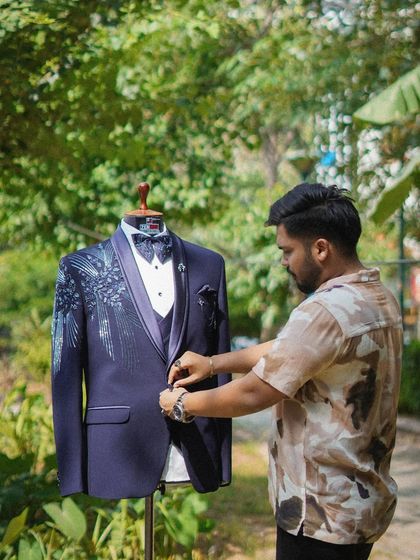 The process of creation is my passion. Here I am adjusting the button on a custom-designed tuxedo, ensuring the fit and fall is absolutely perfect before it reaches my client.