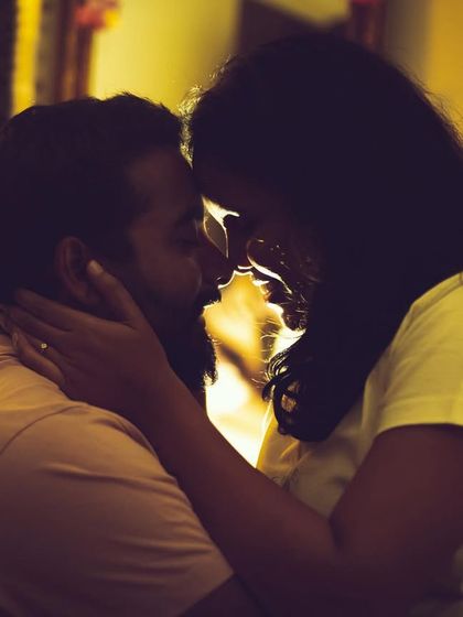 A silhouette of a couple about to kiss, with warm backlighting creating a romantic and tender mood. We use creative lighting techniques to capture emotion.