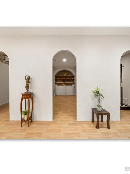 A hallway with a series of elegant archways, creating a beautiful sense of rhythm and flow. The minimalist decor and light wood flooring enhance the feeling of spaciousness and tranquility.