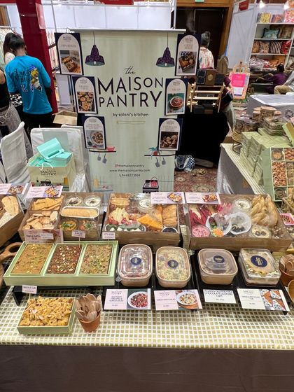 My stall at the Jalsa Exhibition, fully stocked and ready for a busy day. The display features my signature dips box, salads, desserts, and a variety of mithai.