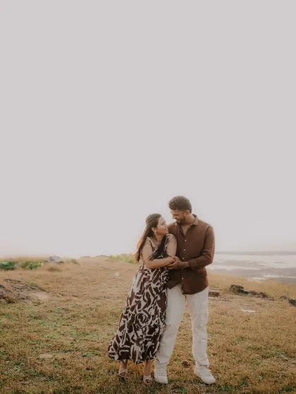 A full-length portrait of the couple embracing in a field. The soft light and natural surroundings create a peaceful and romantic mood.