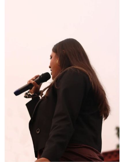A side profile shot of me on the mic, focused on delivering a great show for the audience at a college event.