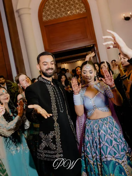 The party begins! A candid shot of the couple making their entrance onto the dance floor, surrounded by happy guests. These are the moments of pure joy we love to facilitate.