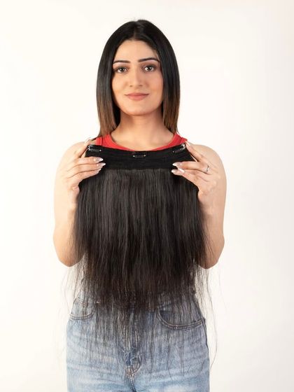 A model holding a full weft of hair, demonstrating the product's thickness.