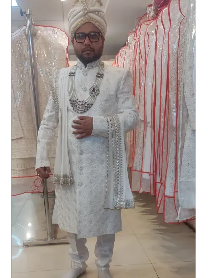 For the grooms, I offer elegant options like this pristine white embroidered sherwani. This rental comes as a complete set with a matching pagri, stole, and a layered pearl necklace.