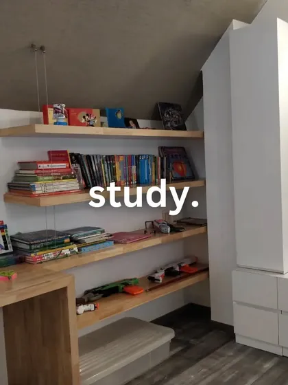 Even a study area can be interesting. We used simple floating wooden shelves and white cabinetry to create a functional and organized study nook under a sloped ceiling.