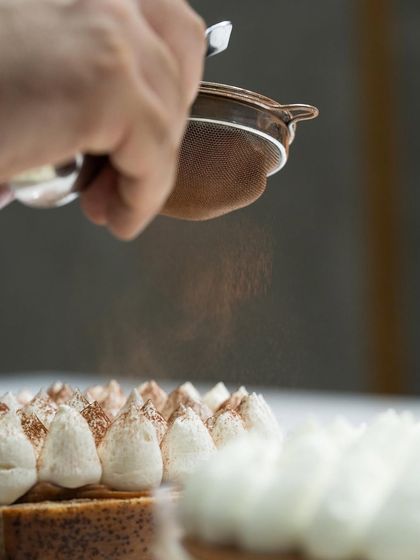 A light dusting of cocoa powder over a tiramisu-style cake, demonstrated by Chef Karim Bourgi.