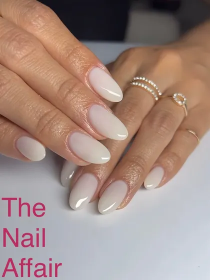 A subtle and chic milky white ombré on almond-shaped nails, offering a sophisticated and clean aesthetic.