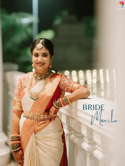 A smiling portrait of the bride, Monika, on her wedding night. Her classic white and red saree and joyful expression are beautifully captured in the evening light.